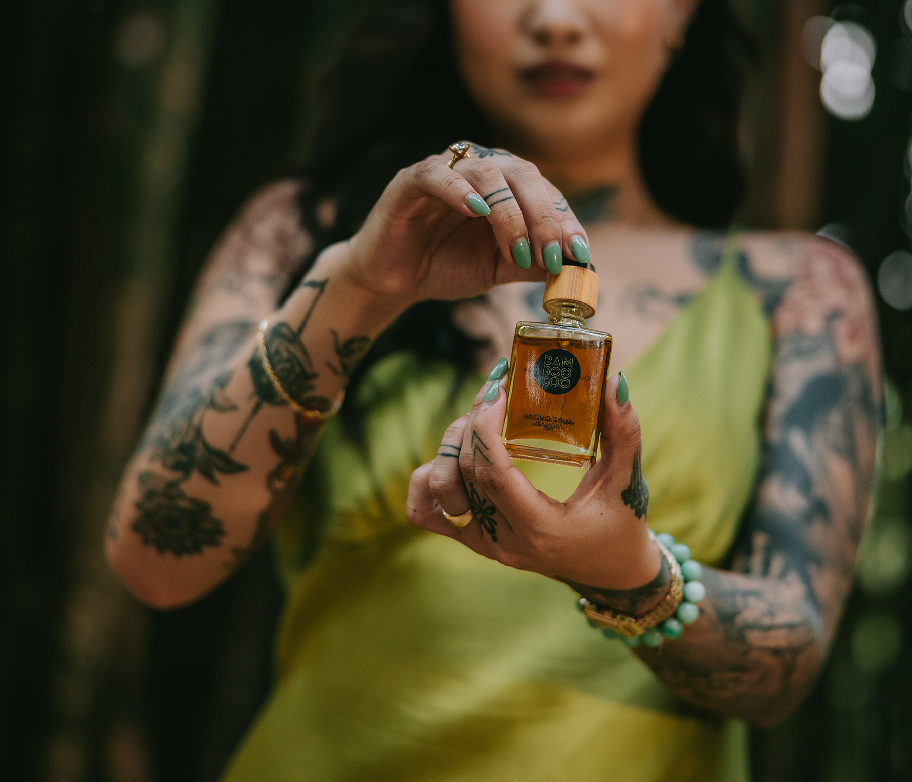 Woman holding a bottle of perfume in a forest setting